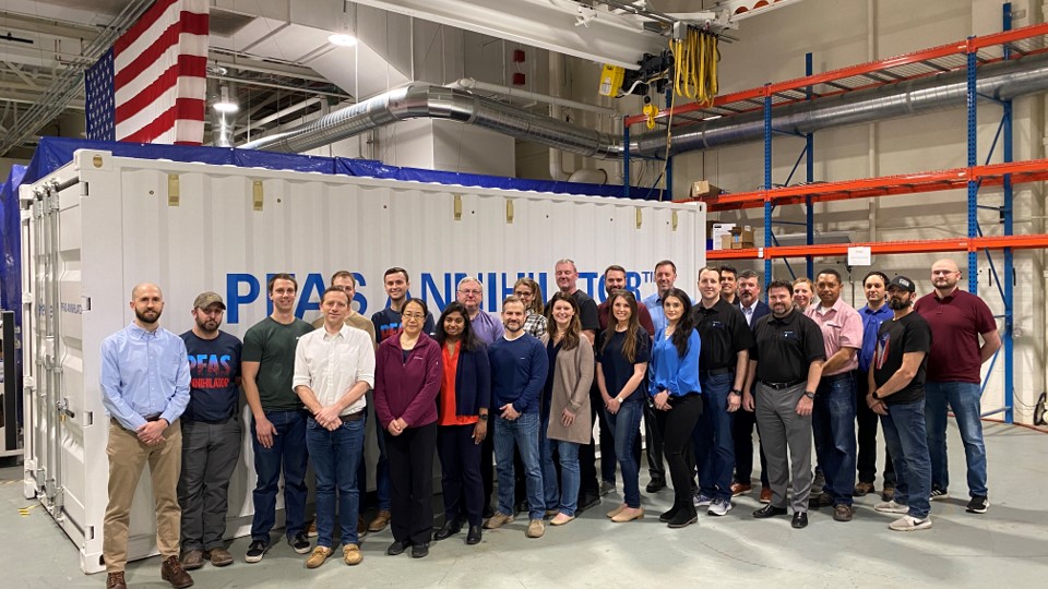 revive and battelle team in front of unit and us flag